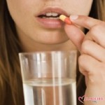 Женщина пьёт лекарство и запивает водой